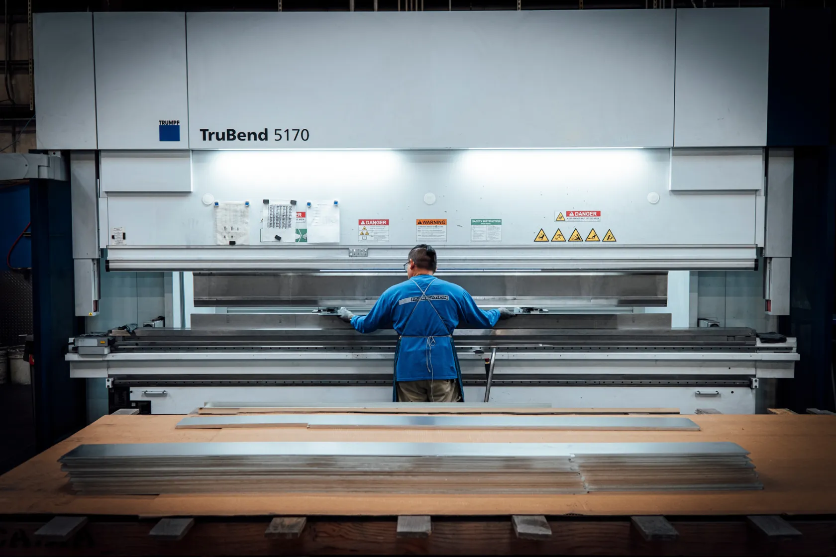 Worker operating a TRUMPF TruBend 5170 press brake machine for precision metal bending at Baldhead Cabinets